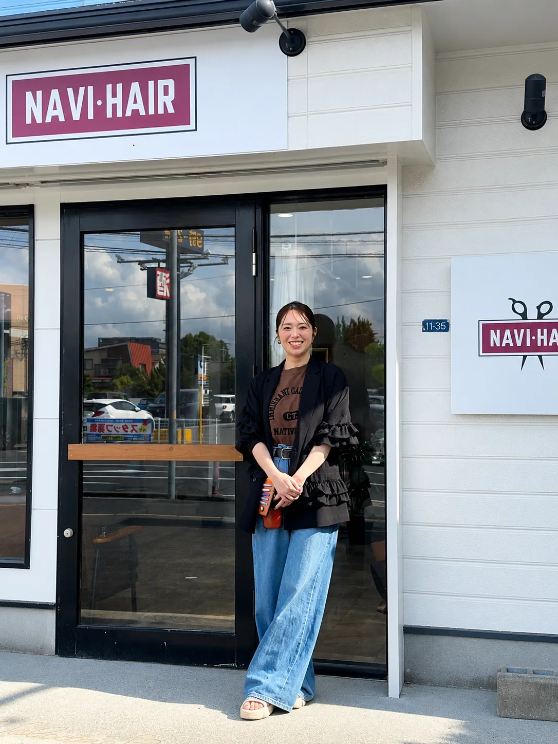 佐賀美容室NAVI・HAIR（ナビヘアー）の店舗前に立つオーナースタイリスト貞富真紀