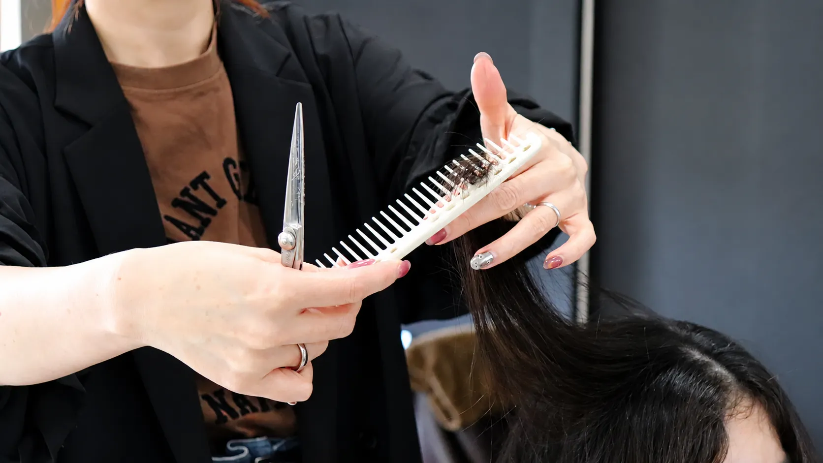 佐賀市赤松の美容室NAVI・HAIRでハサミとコームを使いお客様の髪を丁寧にカットする美容師の手元